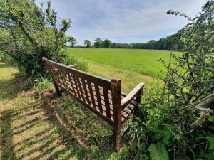 a wooden bench sitting in the middle of a field at The New Forest Manor Apartment in Lymington