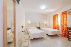 Habitación hospitalaria con 2 camas y espejo en Hotel Manzanito en Antequera