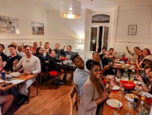 a group of people sitting at tables in a restaurant at Adventure Hostel Interlaken in Interlaken