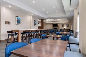 een restaurant met houten tafels en blauwe stoelen bij Comfort Suites in Paducah