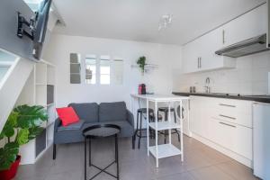 kuchnia z kanapą i stołem w pokoju w obiekcie BENFLEET 4 Cosy studio avec grande terrasse de 25 m2 w mieście Romainville