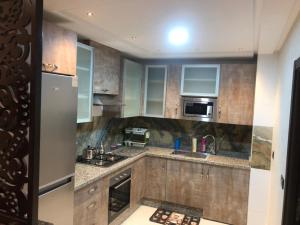 una cocina con armarios de madera y electrodomésticos de acero inoxidable en اقامة العائلة en Nador