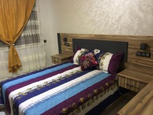 1 dormitorio con cama de madera y almohadas en اقامة العائلة en Nador