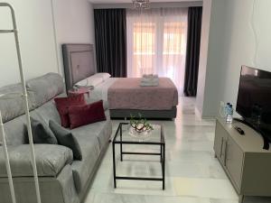 a living room with a couch and a bed at Kentia Rooms in Málaga