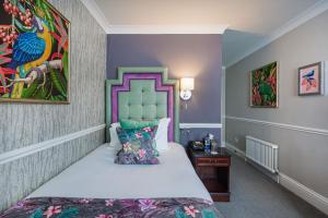 a bedroom with a bed and a painting on the wall at The Crown Hotel, Boroughbridge, North Yorkshire in Boroughbridge