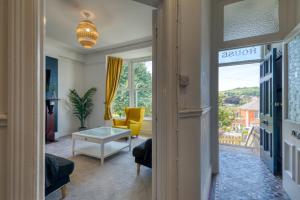 a living room with a door open to a living room at Brent House - 4 bedroom home close to shops, harbour & beaches in Ilfracombe