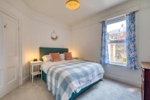 a bedroom with a bed and a window at Brent House - 4 bedroom home close to shops, harbour & beaches in Ilfracombe