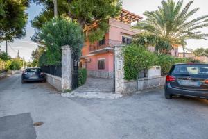 twee auto's geparkeerd voor een huis bij Scuole CEMM San Vito Apartment with parking in Taranto