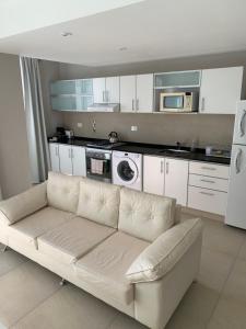 a living room with a white couch in a kitchen at Departamento Villa Los Remeros, Tigre in Tigre