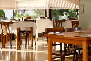 un comedor con mesas, sillas y ventanas en Hotel Blu Aran, en Vielha