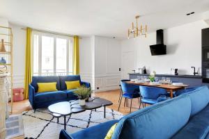 uma sala de estar com sofás azuis e uma mesa em Amazing Appart 3BR-6P - Bastille -Gare de Lyon 3 em Paris