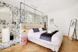 um quarto com uma grande cama branca e um papel de parede floral em Amazing Appart 3BR-6P - Bastille -Gare de Lyon 3 em Paris