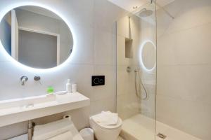 uma casa de banho com um chuveiro, um WC e um espelho. em Amazing Appart 3BR-6P - Bastille -Gare de Lyon 3 em Paris
