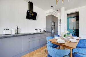 uma cozinha com uma mesa de madeira e cadeiras azuis em Amazing Appart 3BR-6P - Bastille -Gare de Lyon 3 em Paris