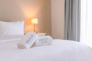 Una habitación de hotel con una cama con dos toallas. en New fully serviced 1BR Apartment en Al Ain