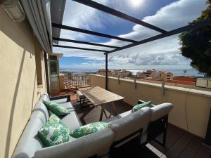 balcón con sofá y mesa en el techo en Marble Apartments, en San Andrés