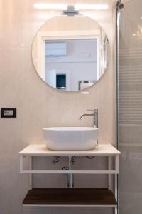 W łazience znajduje się umywalka i lustro. w obiekcie Le Dimore del Centrale w mieście Macerata