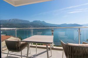 a table and chairs on a balcony with a view at Bliss on the Bay in Njivice