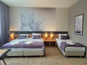 een slaapkamer met 2 bedden en een schilderij aan de muur bij HOTEL PORT 2000 Torzym in Torzym