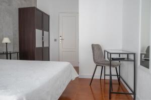 a bedroom with a bed and a chair and a table at Hostal Tokio in Madrid