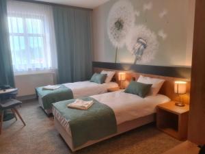 a hotel room with two beds and a desk at HOTEL PORT 2000 Torzym in Torzym