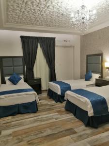 um quarto de hotel com duas camas e um lustre em مساس الخليج Mesas Gulf وحدات سكنية em Dammam