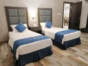 Habitación de hotel con 2 camas y almohadas azules en مساس الخليج Mesas Gulf وحدات سكنية en Dammam