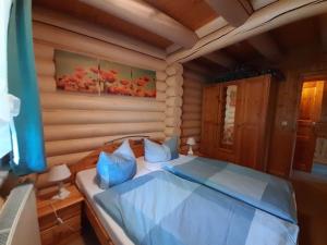 um quarto com uma cama num chalé de madeira em Log cabin in Harzgerode with balcony em Dankerode