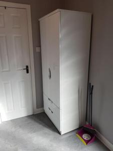 biała szafka w pokoju z drzwiami w obiekcie Craigellachie Cabin w Aviemore