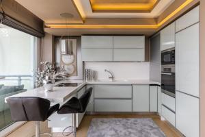 a kitchen with white cabinets and a table and chairs at Mega suite on the sea in Perea