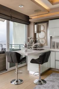a kitchen with black chairs and a white counter top at Mega suite on the sea in Perea
