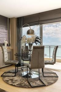 a living room with a table and chairs and a balcony at Mega suite on the sea in Perea