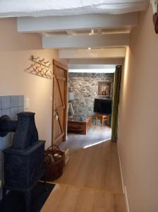 a hallway with a stove in a room with a stone wall at Le Clos du Cerf - La Renardière in Stoumont