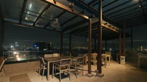 eine Terrasse mit einem Tisch und Stühlen auf dem Dach in der Unterkunft RedDoorz Premium @ West Avenue Quezon City in Manila