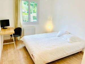 a bedroom with a bed and a desk and a window at VILLA GIULIA - 5min Roissy Airport - 20min Disney in Gressy