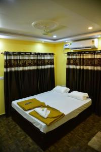a bedroom with a large bed with black curtains at Atlantis Beach Resorts in Kumta
