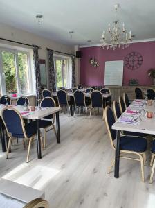 una sala da pranzo con tavoli, sedie e lampadario a braccio di B&B De l' Aisne a Durbuy