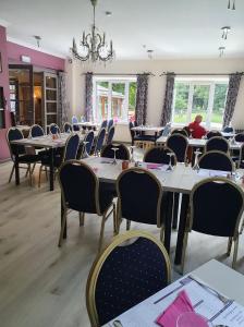 un comedor con mesas y sillas y una lámpara de araña en B&B De l' Aisne en Durbuy