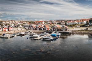 un grupo de barcos atracados en un puerto con casas en Havets Magasin en Väjern