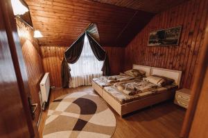 um quarto com uma cama num quarto de madeira em Toga cottage em Yablunytsya