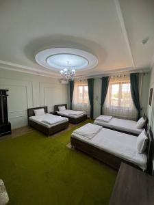 a large room with two beds and a chandelier at Tomaris in Nukus