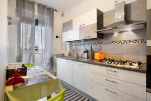 una cocina con armarios blancos y una mesa. en Sweet Chloe Milano, en Milán