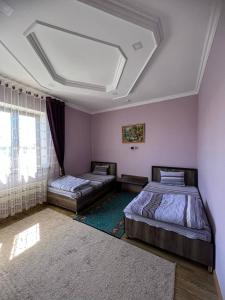 1 dormitorio con 2 camas y ventana grande en Tomaris, en Nukus