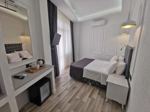 um quarto de hotel com uma cama e um espelho em Efzen hotel em Istambul