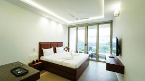 a bedroom with a bed and a large window at Silver Mist in Kodaikānāl