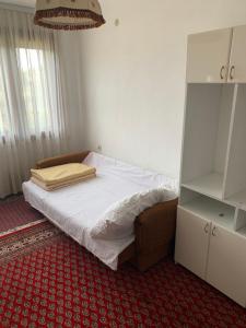 a bedroom with a bed with white sheets and a red carpet at Vila Borova Tara in Kremna