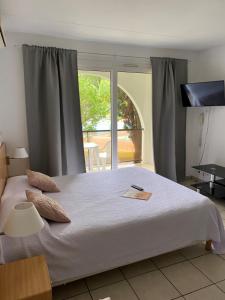 Un dormitorio con una gran cama blanca y una ventana en Hotel Résidence Anglet Biarritz-Parme, en Anglet
