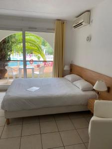 a bedroom with a large bed and a balcony at Hotel Résidence Anglet Biarritz-Parme in Anglet