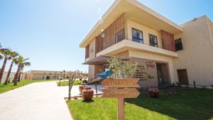a bird sitting on a sign in front of a house at Tulum Beach Resort Dakhla in Dakhla