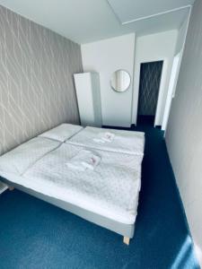 uma pequena cama num quarto com tapete azul em Apartmány Bryksova em Praga